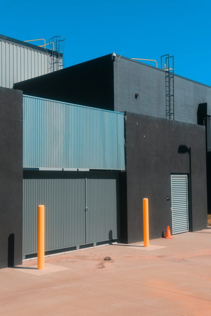 Industrial building with gate under a blue sky.