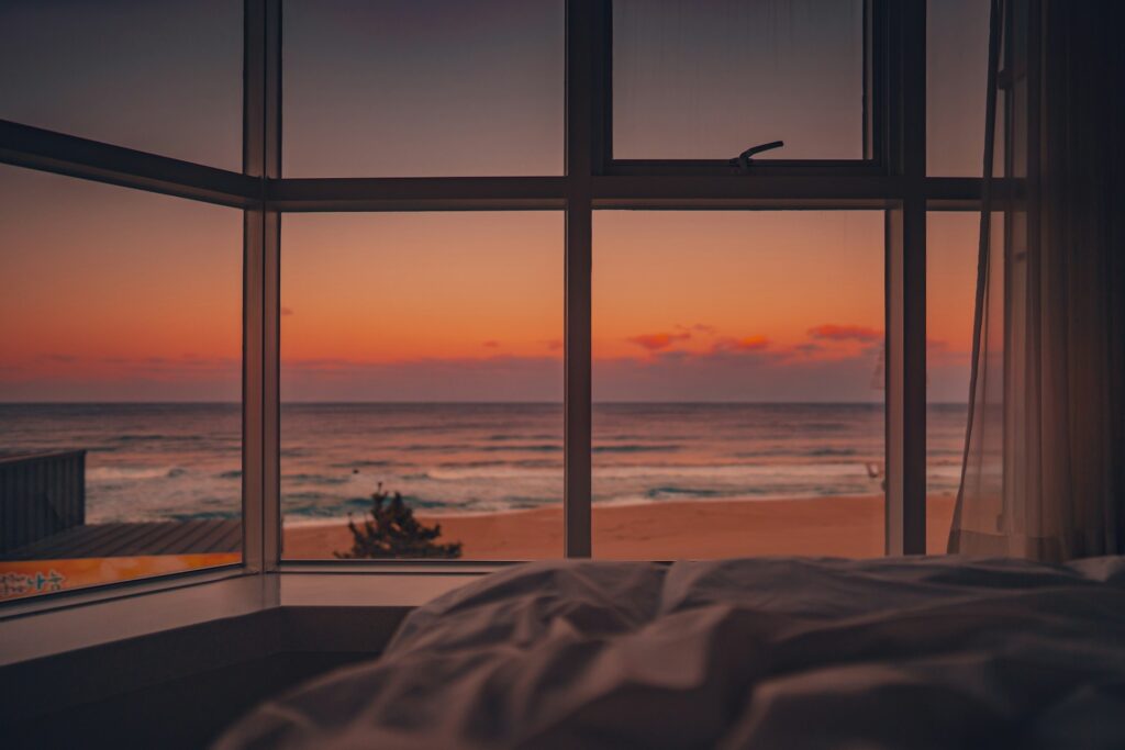 silhouette of person sitting on chair near window during sunset