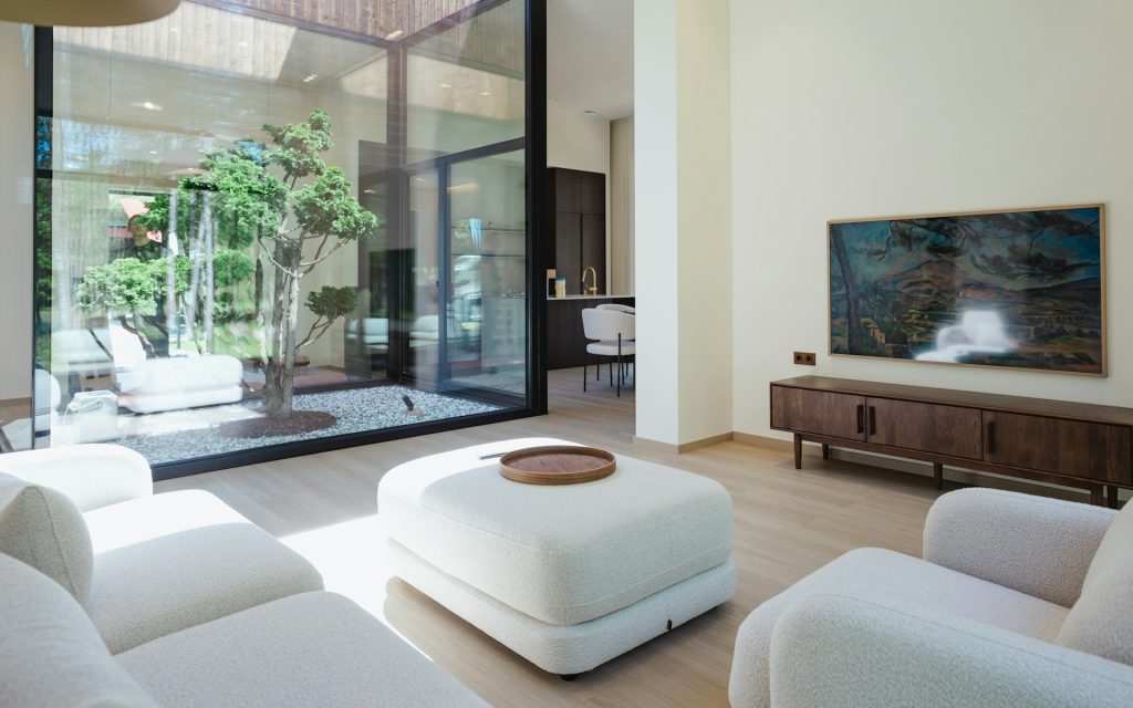 Modern living room with courtyard view and television.